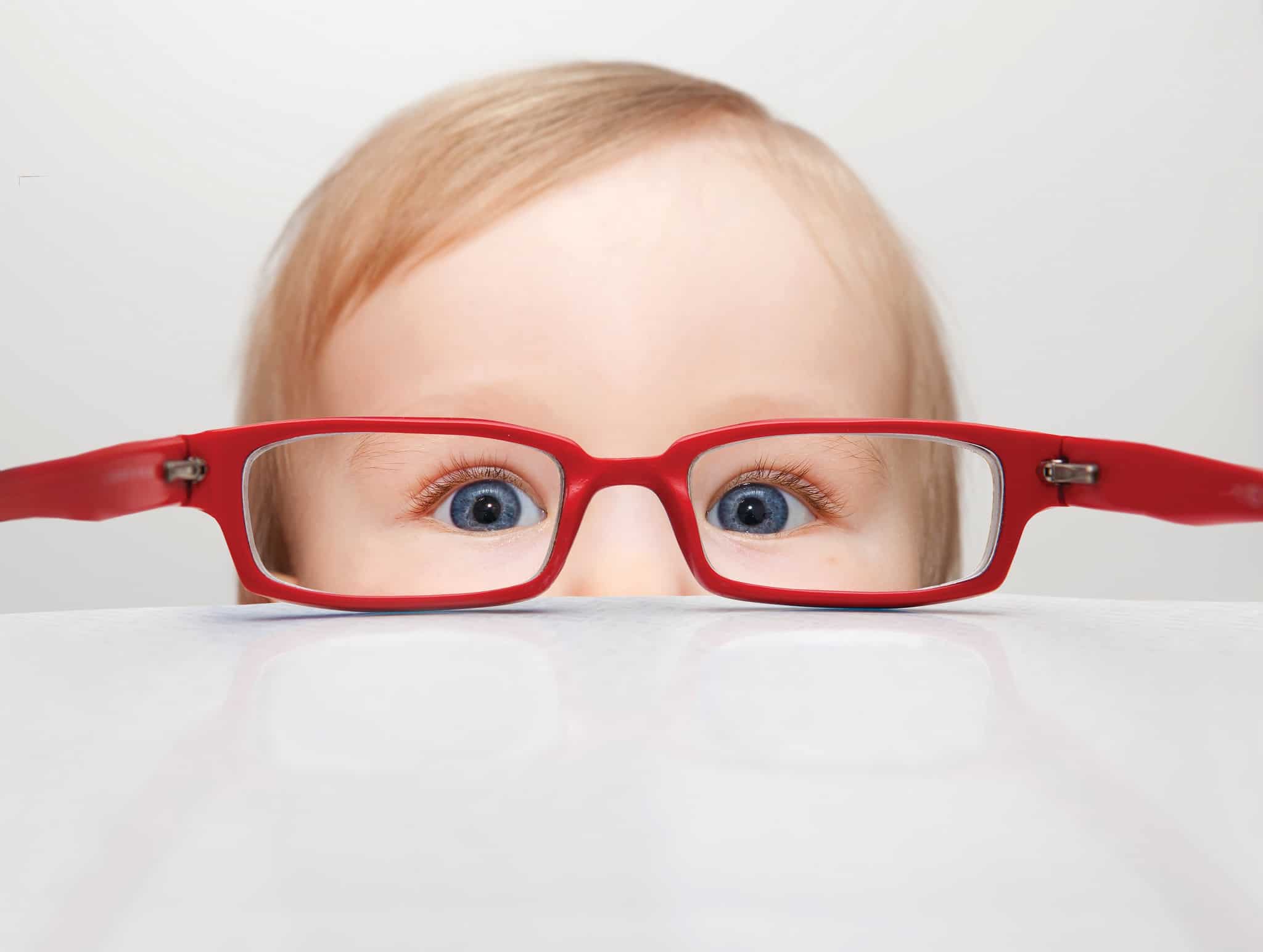 Child looking through red glasses