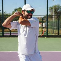 Man wearing sunglasses while playing tennis